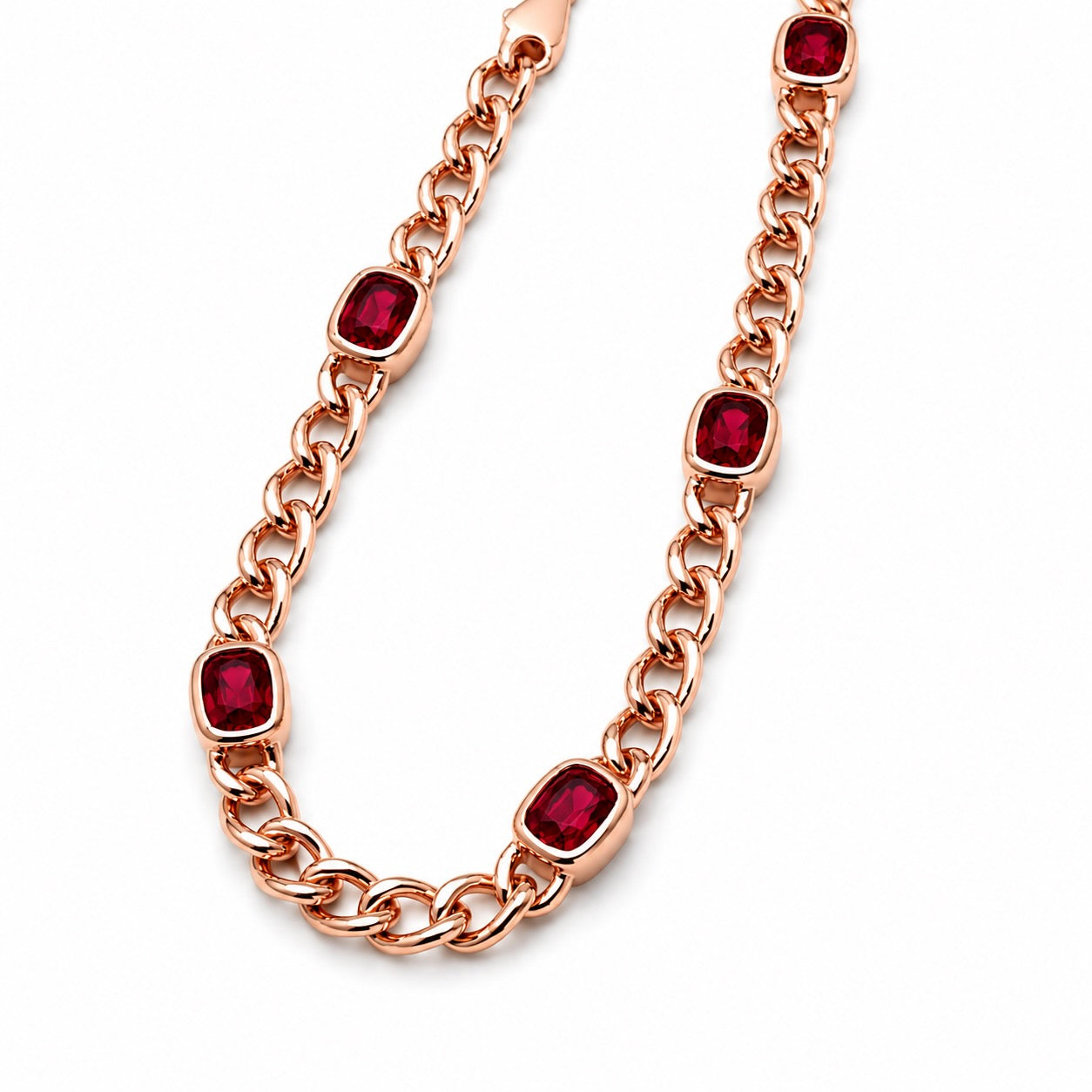 A rose gold chain bracelet featuring cushion-cut rubies set in bezels, displayed on a clean white background.