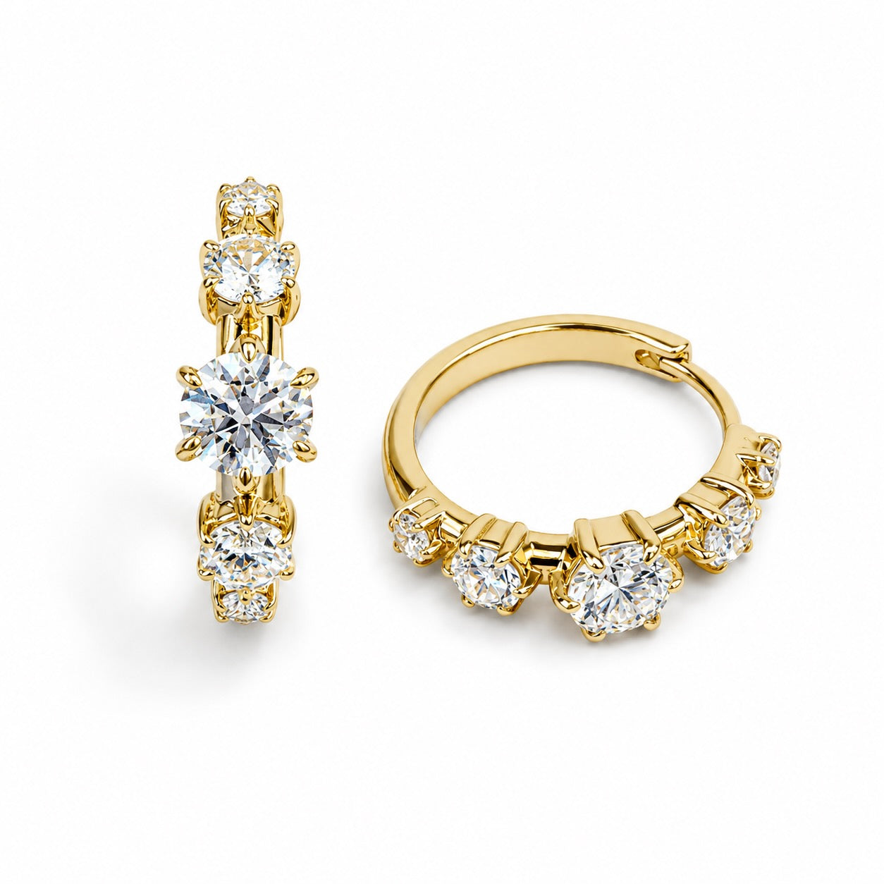 A pair of gold hoop earrings with five round-cut clear gemstones each, set in a vertical arrangement on a clean white background.